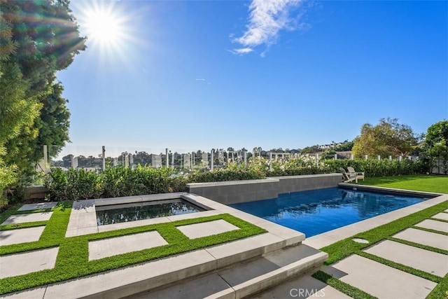 view of swimming pool with a hot tub