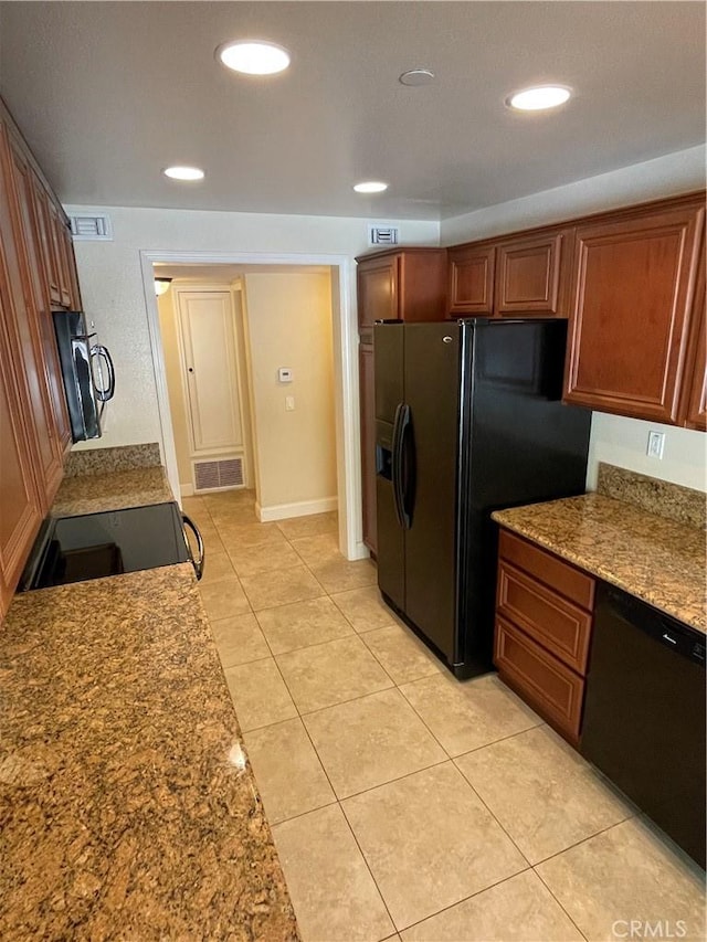 kitchen with black appliances, light tile patterned flooring, and light stone countertops