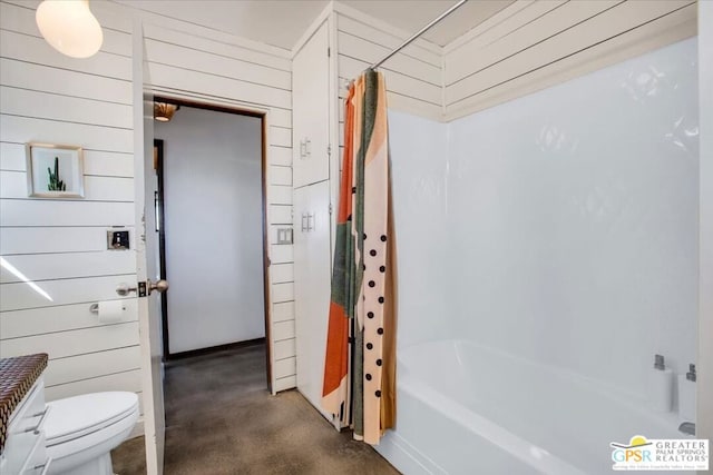 bathroom with toilet, wooden walls, shower / bath combination with curtain, and concrete flooring