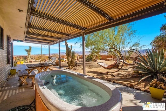 view of pool with a mountain view and a hot tub