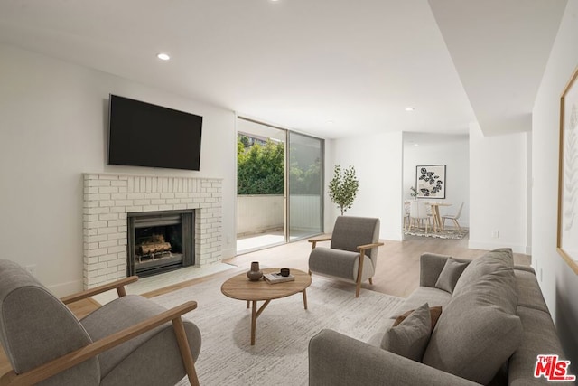 living room featuring light hardwood / wood-style floors and a brick fireplace