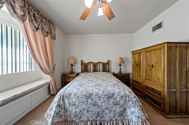 bedroom with ceiling fan and light colored carpet