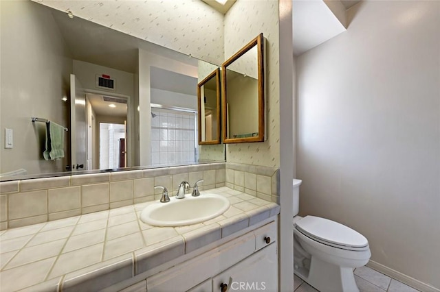 bathroom with tile patterned floors, vanity, toilet, and backsplash