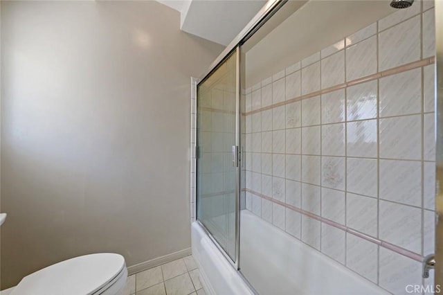 bathroom featuring tile patterned floors, bath / shower combo with glass door, and toilet