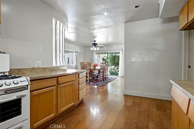 kitchen featuring white stove, light hardwood / wood-style flooring, and ceiling fan