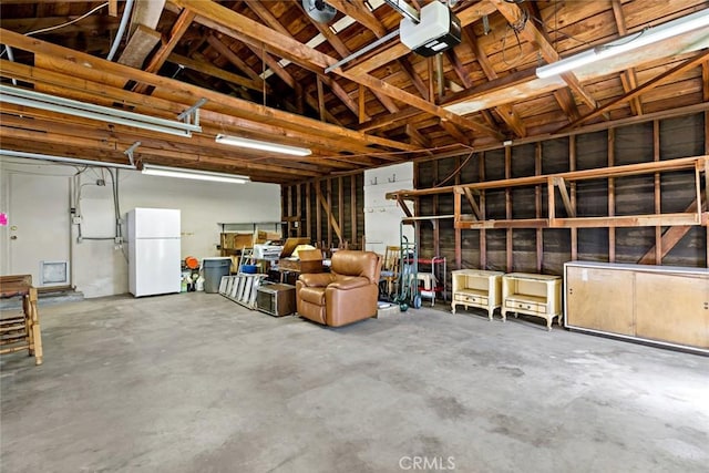 garage featuring white fridge and a garage door opener