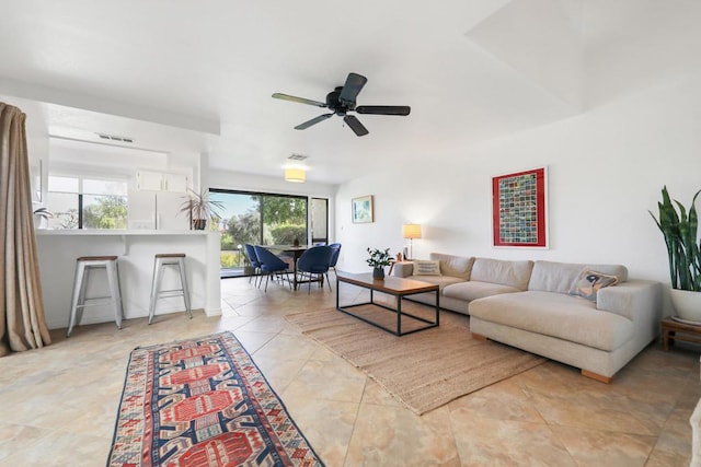 tiled living room with a wealth of natural light and ceiling fan