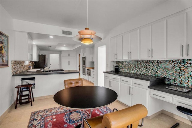 kitchen with sink, decorative backsplash, white cabinetry, and stainless steel appliances