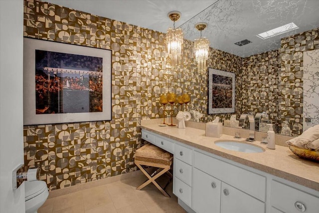 bathroom featuring a textured ceiling, toilet, tile patterned floors, vanity, and an inviting chandelier