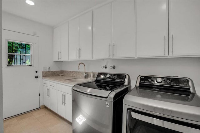 laundry area with sink, washing machine and dryer, and cabinets