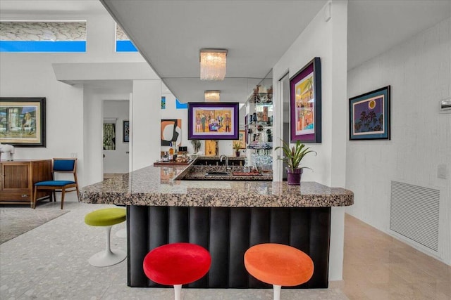 bar featuring sink and stone countertops