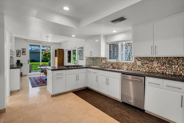 kitchen featuring kitchen peninsula, decorative backsplash, appliances with stainless steel finishes, white cabinetry, and sink