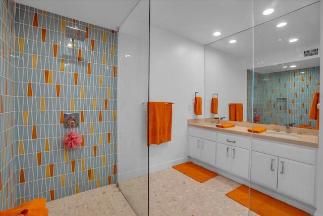 bathroom with vanity, a shower, and tile walls