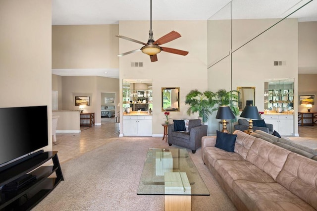 living room featuring ceiling fan, carpet, and a high ceiling