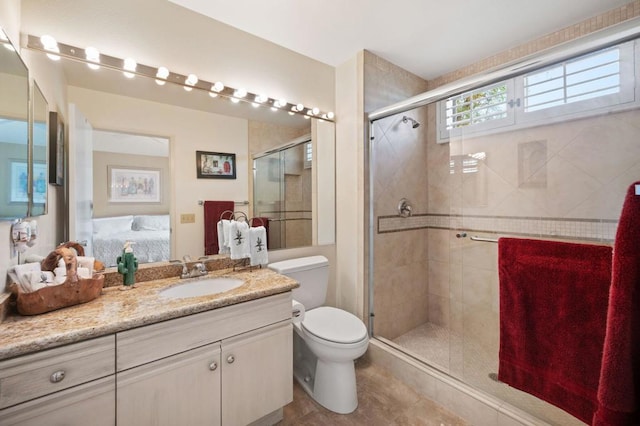 bathroom featuring tile patterned floors, toilet, vanity, and walk in shower