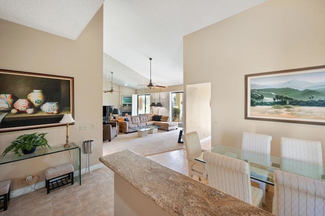 dining area with high vaulted ceiling, ceiling fan, and light tile patterned flooring