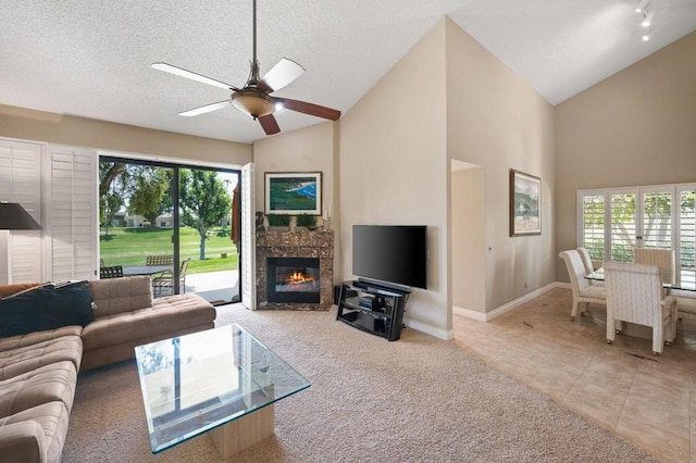 living room with ceiling fan, plenty of natural light, light tile patterned floors, and a textured ceiling