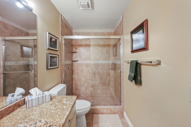 bathroom featuring tile patterned flooring, vanity, a shower with shower door, and toilet