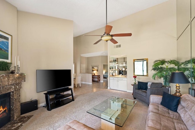 carpeted living room with a fireplace, high vaulted ceiling, and ceiling fan