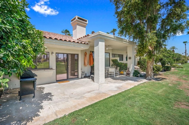 rear view of property with a patio, ceiling fan, and a lawn