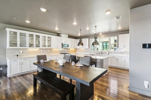 dining area with sink and dark wood-type flooring