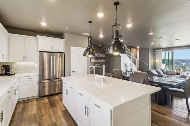 kitchen featuring high end refrigerator, dark hardwood / wood-style floors, a kitchen island, and white cabinets