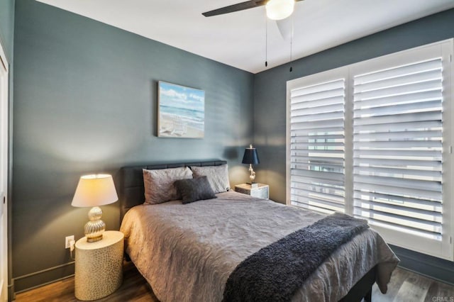 bedroom with dark hardwood / wood-style flooring and ceiling fan