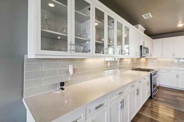 kitchen featuring white cabinetry, glass insert cabinets, dark wood-style flooring, and stainless steel appliances