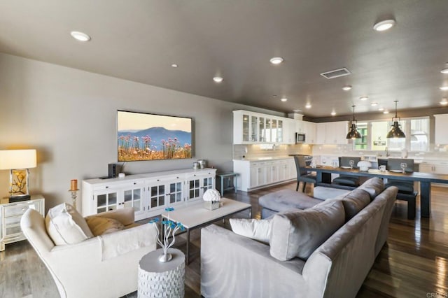 living area with dark wood-type flooring, recessed lighting, and visible vents