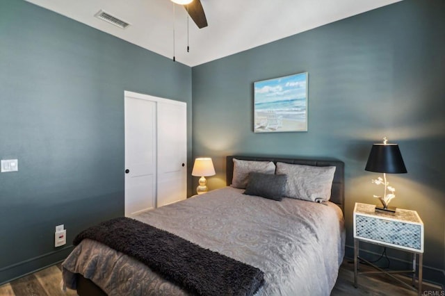 bedroom featuring visible vents, a closet, wood finished floors, and a ceiling fan