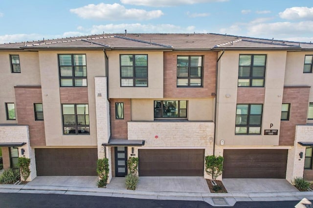 multi unit property featuring stucco siding, a garage, and concrete driveway