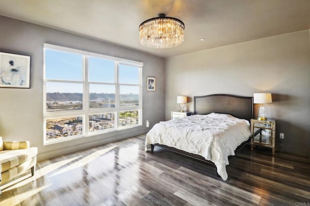 bedroom with an inviting chandelier and wood finished floors