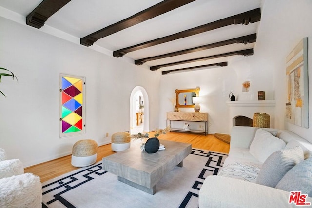 living room with beamed ceiling and light wood-type flooring