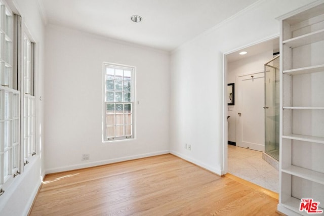 empty room with light hardwood / wood-style floors and ornamental molding