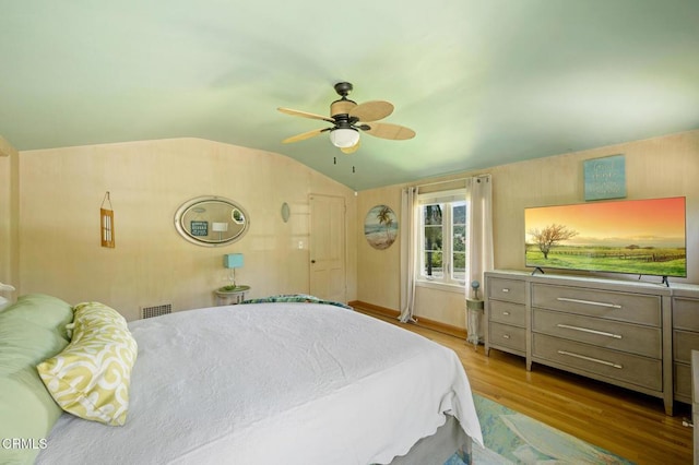 bedroom with ceiling fan, light wood-type flooring, and vaulted ceiling