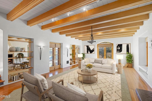 living room featuring light wood-type flooring, rail lighting, french doors, and beamed ceiling