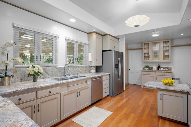 kitchen with decorative light fixtures, decorative backsplash, sink, light wood-type flooring, and stainless steel appliances