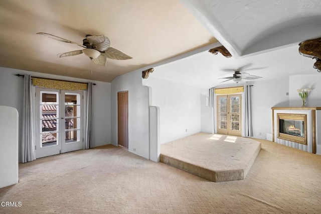 unfurnished living room featuring light carpet, vaulted ceiling with beams, french doors, and ceiling fan