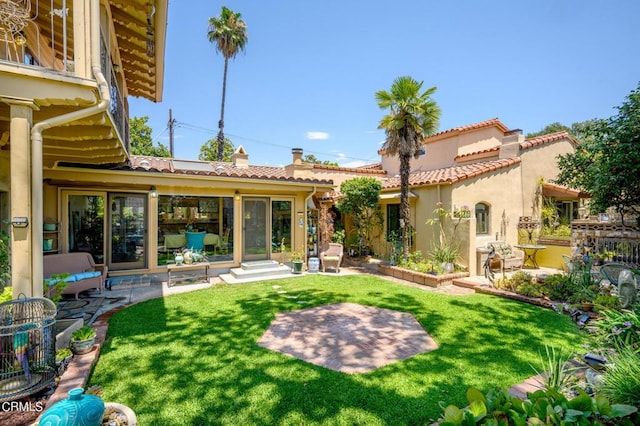 back of house with a patio area and a yard