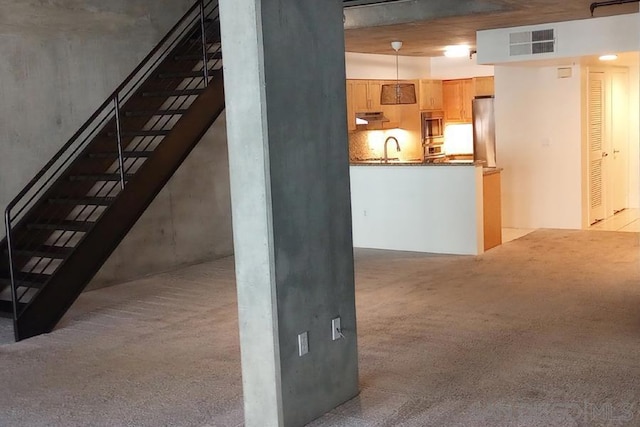 interior space featuring light carpet, stainless steel refrigerator, and sink