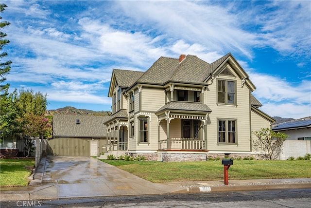 view of front facade featuring covered porch, a garage, and a front lawn