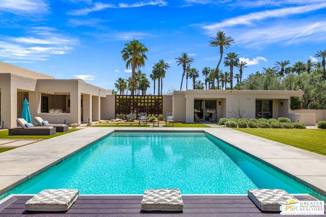 view of swimming pool featuring a patio and a lawn