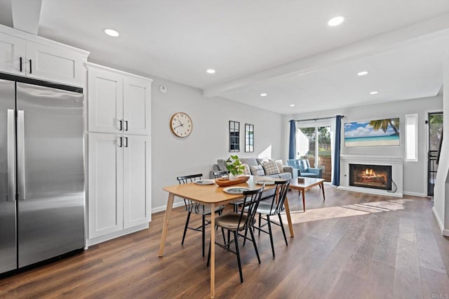 dining room featuring dark wood-type flooring and beam ceiling