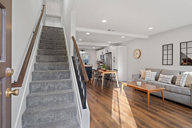 staircase featuring hardwood / wood-style floors and beamed ceiling