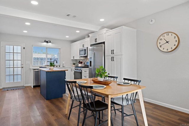 dining room with beamed ceiling, dark hardwood / wood-style floors, and sink