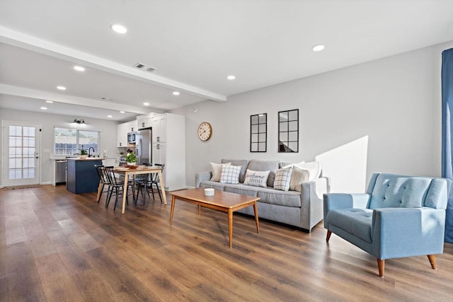 living room featuring dark wood-type flooring and beam ceiling