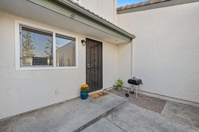 view of exterior entry with a patio area