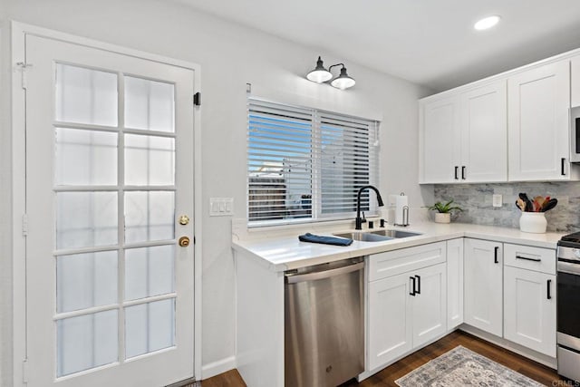 kitchen with dark wood-type flooring, sink, tasteful backsplash, appliances with stainless steel finishes, and white cabinets