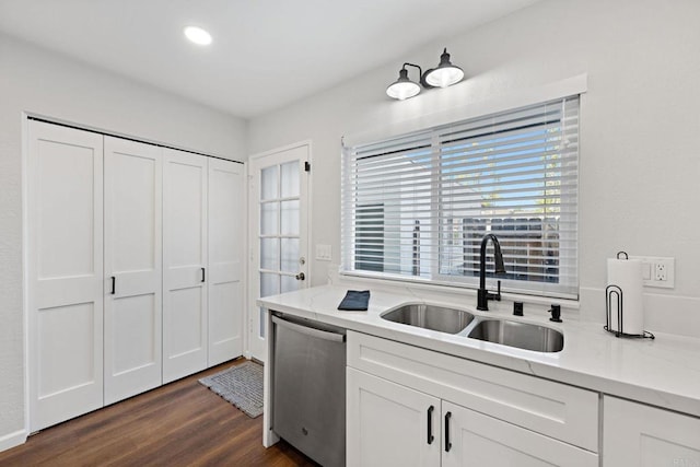 kitchen featuring dark wood-type flooring, sink, stainless steel dishwasher, light stone countertops, and white cabinets