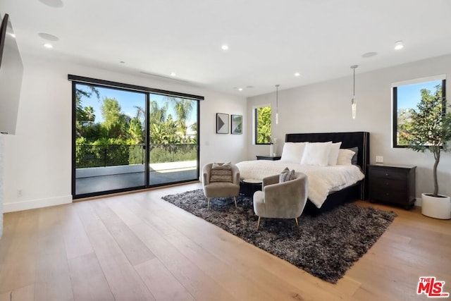 bedroom with access to outside, multiple windows, and light hardwood / wood-style flooring